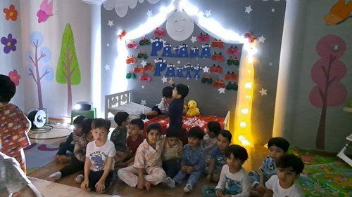Children gathered for a pyjama party under fairy lights